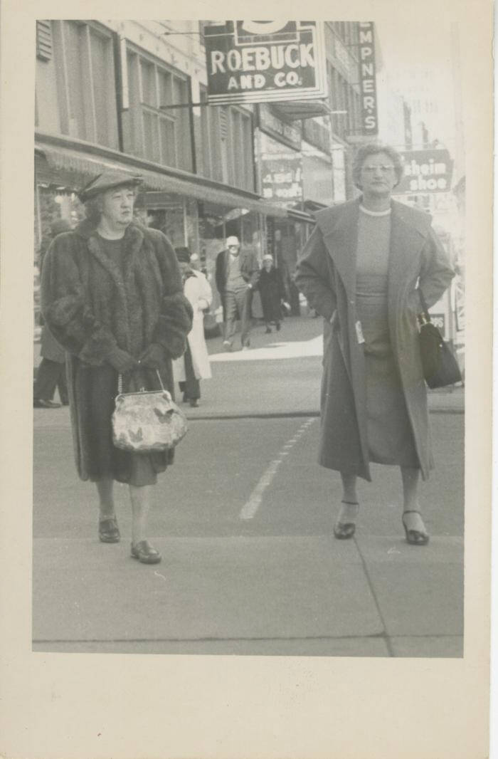 Black and white photograph of two women in a street.